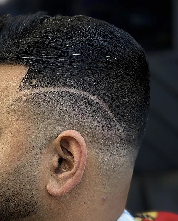 Costado con una línea curva rasurada que sigue la forma del degradado sobre la oreja